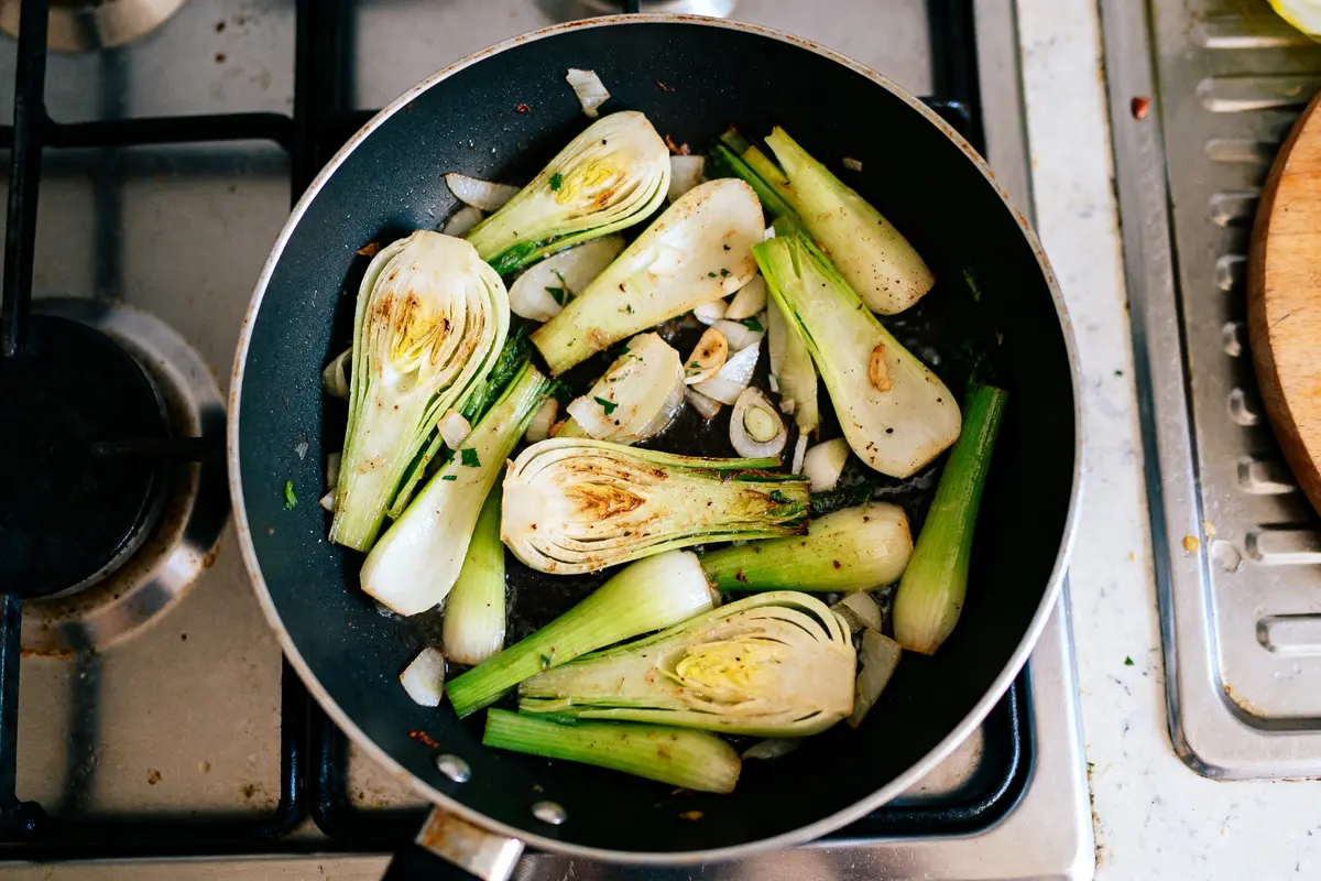 Tranches de poireaux sautées dans une poêle pour optimiser le temps de cuisson des poireaux